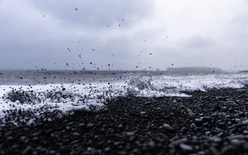 Wave kicking up rocks at Reynisfjara Beach