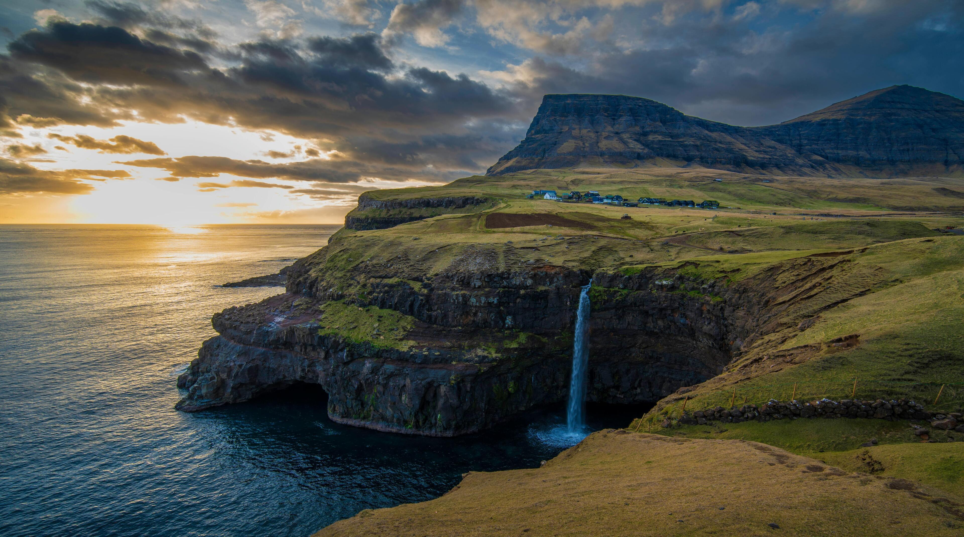 Múlafossur Waterfall plunging into the North Atlantic at sunset, Gásadalur, Faroe Islands
