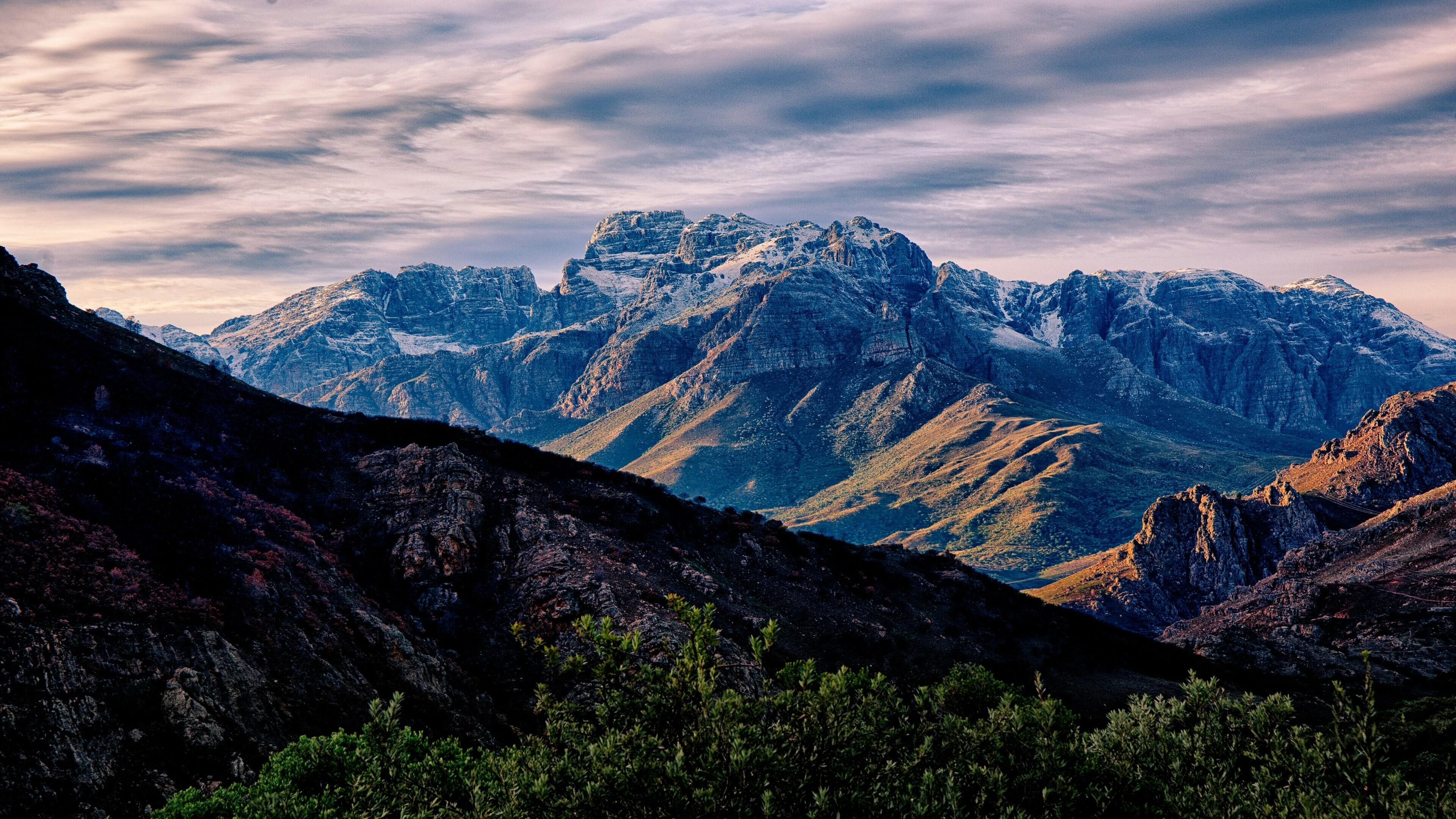 Snow-Dusted Peaks at Golden Hour - A Mountain Range Bathed in Warm Light