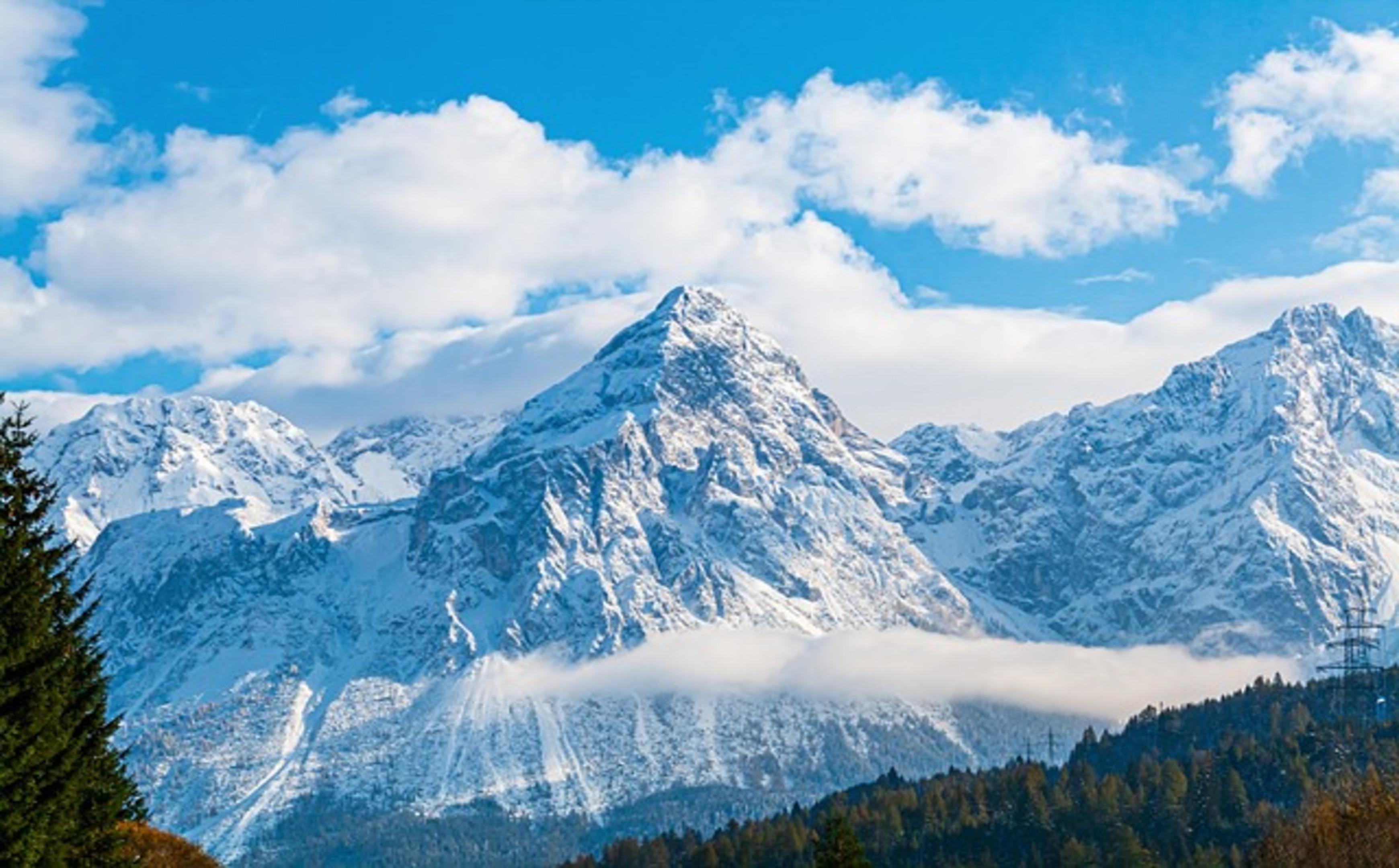 Majestic Snow-Capped Peaks Rising Above the Clouds