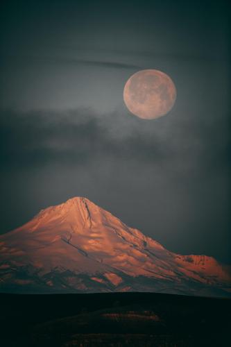 As seen from Roosevelt WA. The full moon begins to set behind Mt. Hood.