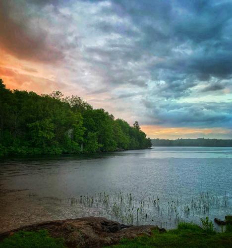 Sunset and thunderstorm converge on Long Lake, South Frontenac County, Ontario Canada