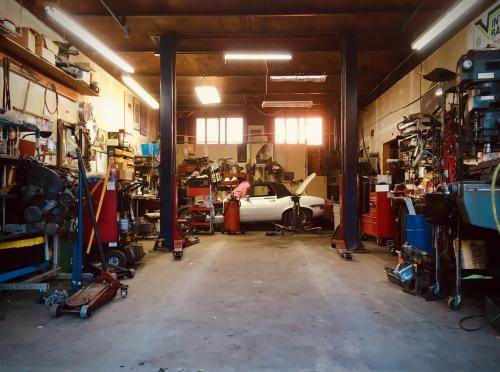 Can you tell what car is in the back of this little shop? Hint: it has a V12
