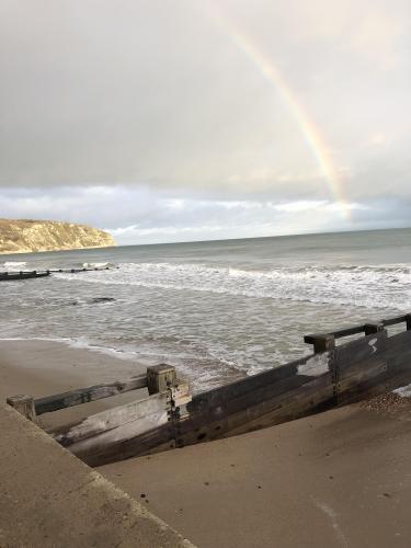 A rainbow over the cliffs and ocean - Swanage, England