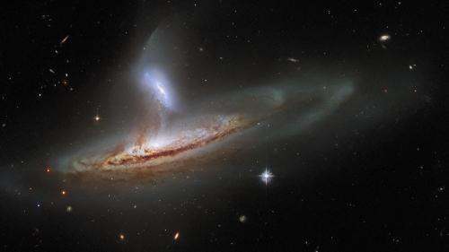 Hubble: A Cosmic Draw. Large galaxy pulling stars and gas from a smaller galaxy. [3840 x 2160]