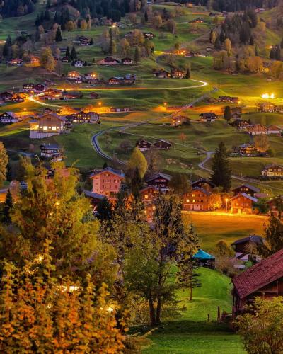 Chalets on the rolling green hills of Grindelwald, Canton of Bern, Switzerland.