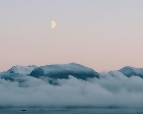 The moon at sunrise. Overlooking the Molde fjord and panorama, west coast of Norway.