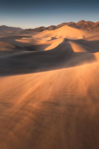 Golden hour light on sand dunes in Death Valley National Park, CA