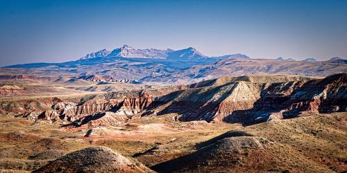 Sun rising on the distant Absaroka Range. Looking across some clay hills behind a wonderful little town called Dubois, WY. [6819x3411] 