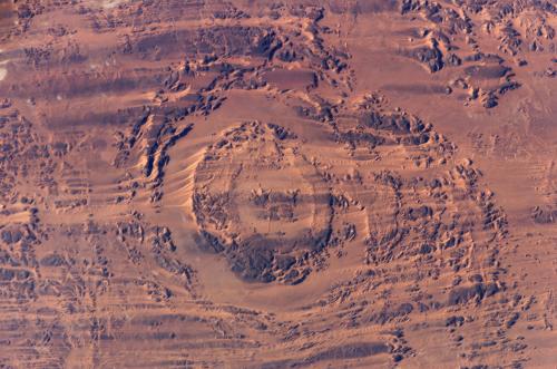 The "Aorounga impact crater" located "in the Sahara Desert of northern Chad" photographed from the International Space Station on November 29, 2005. "The area shown is centered at approximately 19.1 degrees north latitude and 19.3 degrees east longitude."