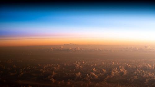 "The soft hues of an orbital sunrise begins revealing the cloud tops above the Pacific Ocean northeast of New Zealand as the International Space Station orbited 260 miles above" on February 10, 2023.