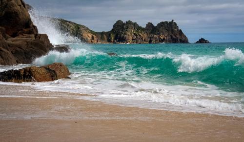 Waves crashing into the rocks at Porthcurno Beach, Cornwall, UK