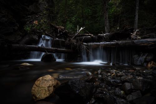 A fallen tree blocks a waterfall in Grande Cache Alberta Canada.  [2560X1707]