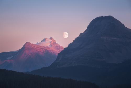 Moonrises as the sun sets, Alberta, Canada.