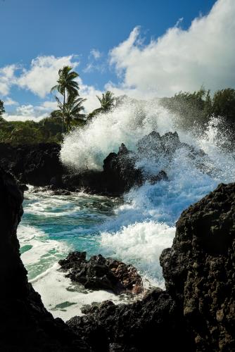 Waves crash against the lava rock coast of Maui, Hawaii