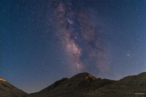 Last rays of the setting moon shining off of the peaks of the southern terminus of the Last Chance Mountains, Death Valley, California.