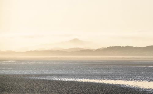 Sun rising over foggy hills, on the shore of the Channel sea  ig : kalaabaaz