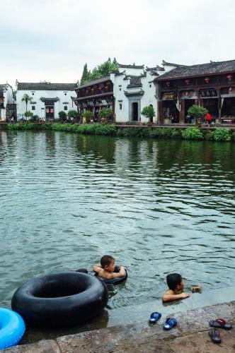 Children playing with car tires as life buoys in Zhuge Village  2010 LanXi JinHua ZheJiang China