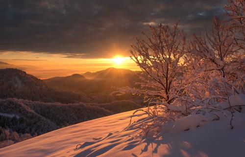 Silhouette of mountain under cloudy sky