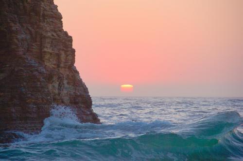 A long trail of the sun during a misty sunset, Davenport Beach, CA