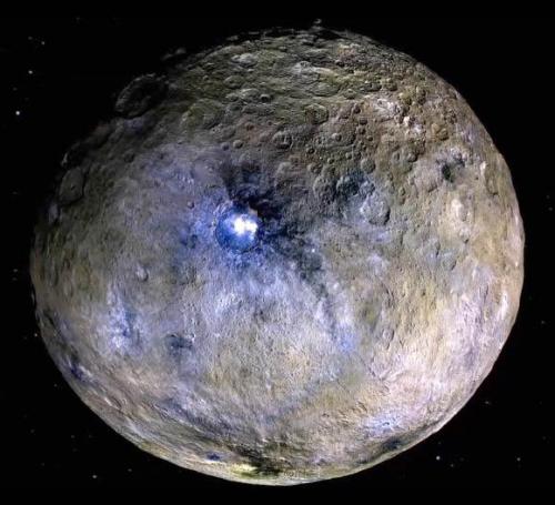 The dwarf planet Ceres has a bright blue spot in the crater which is actually salt. This is the only dwarf planet that has the closest earthly features on it.